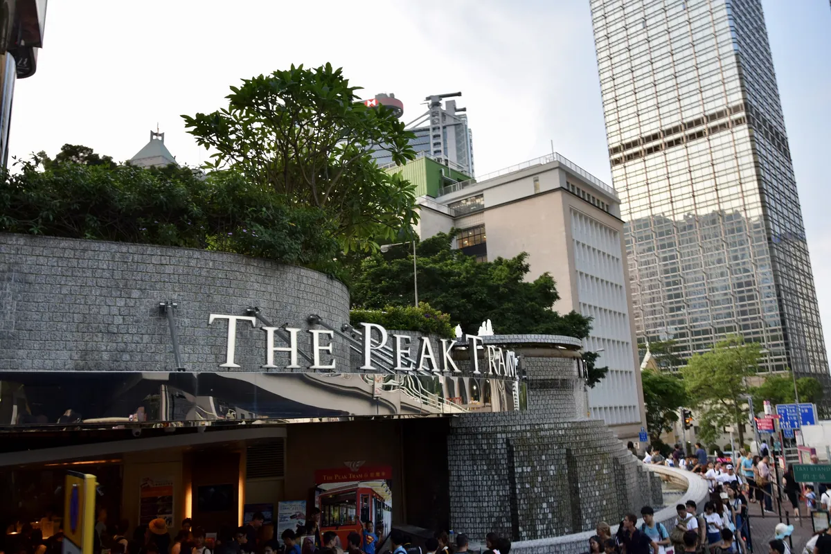 The Peak Tram entrance sign on Garden Road in Central, with office towers behind it